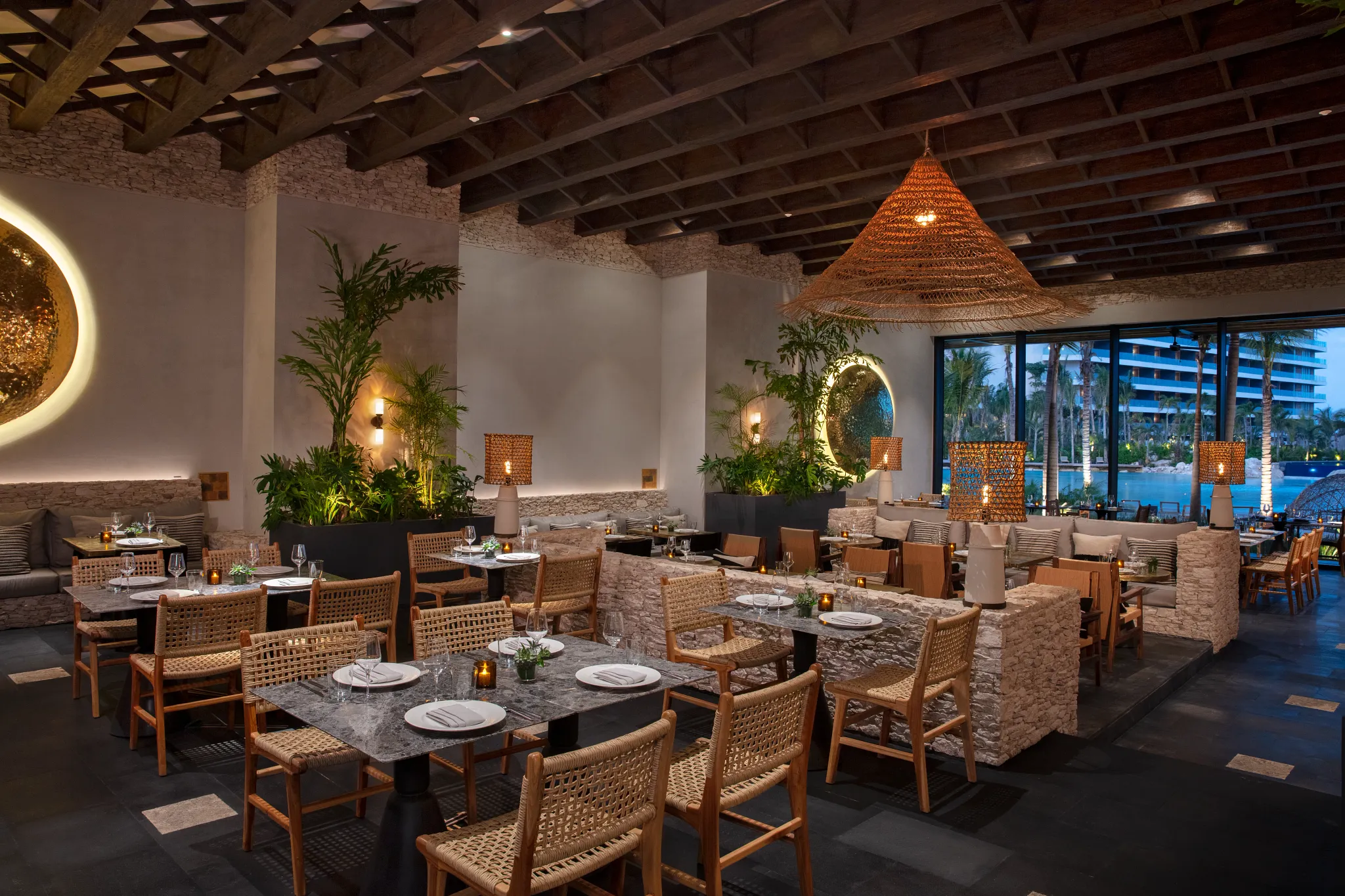 Dos Almas Mexican restaurant at Impression Moxché by Secrets featuring rustic-chic décor, woven lighting, stone accents, and elegant indoor dining.