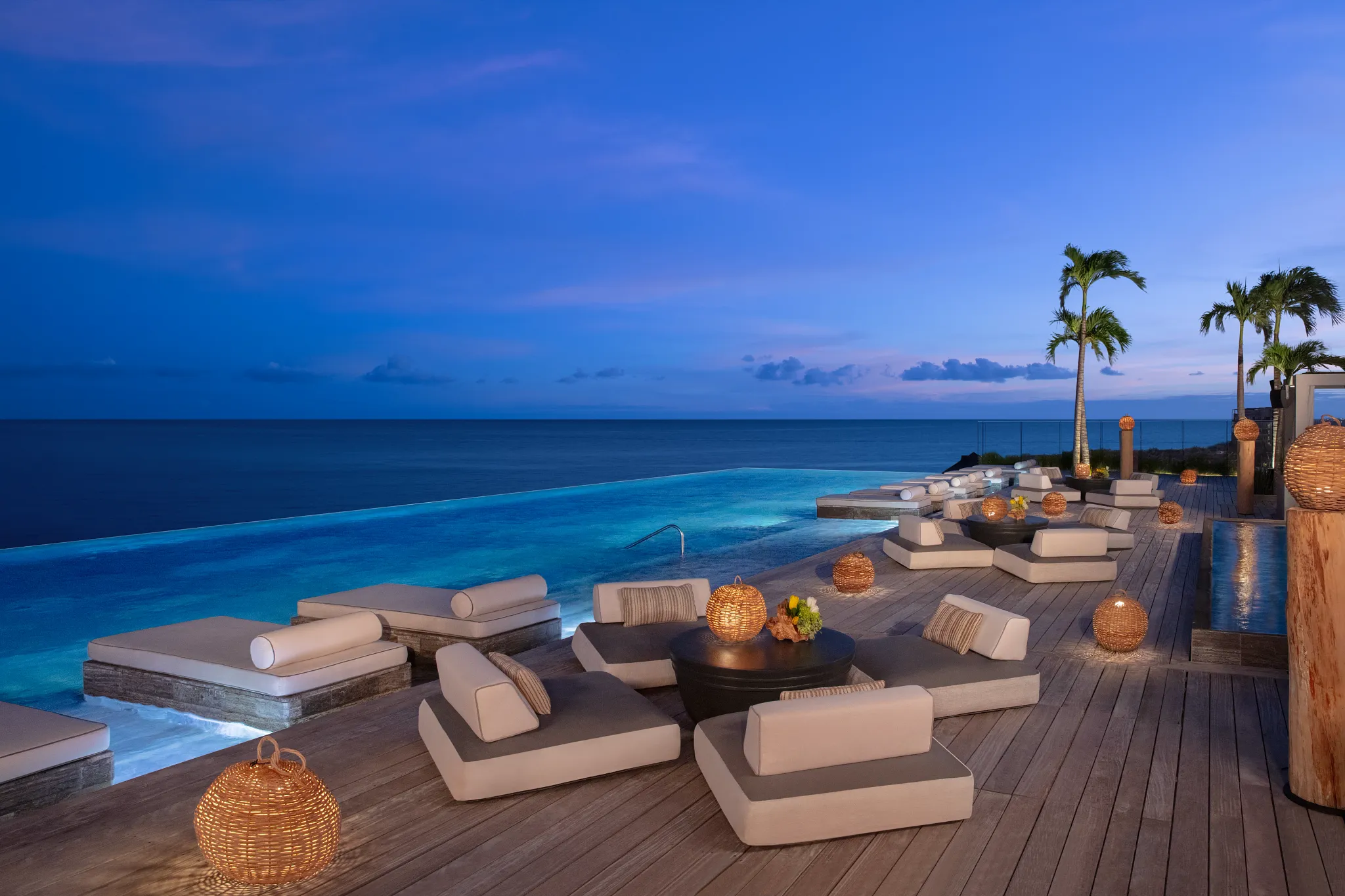 Evening rooftop infinity pool lounge with ocean views at Impression Moxché by Secrets.