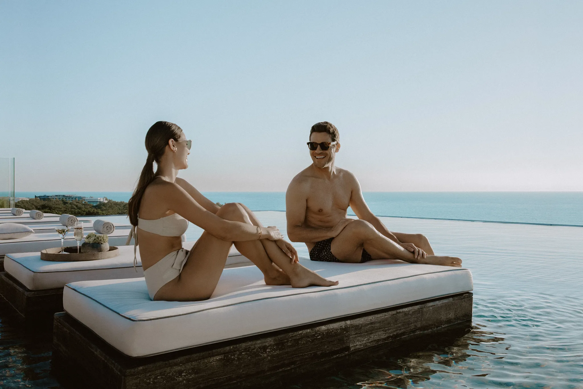 Couple lounging poolside on a rooftop terrace at Impression Moxché by Secrets in Playa del Carmen.