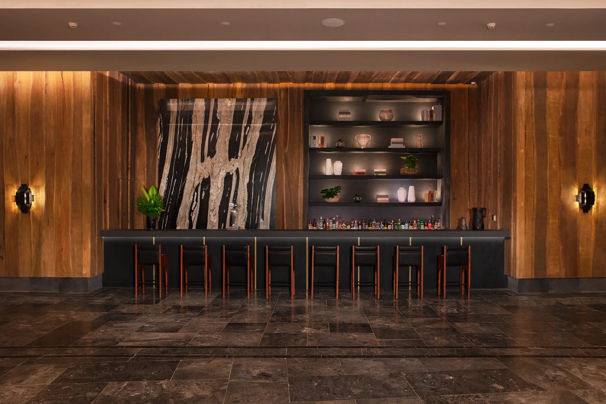 Moxché Lobby Bar at Impression Moxché by Secrets featuring sleek dark marble bar, warm wood accents, and modern upscale ambiance.