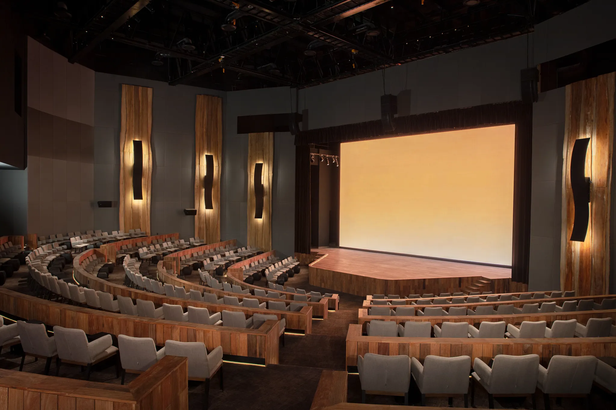 Moxché Theatre at Impression Moxché by Secrets featuring modern auditorium seating, large stage screen, and upscale evening entertainment venue.