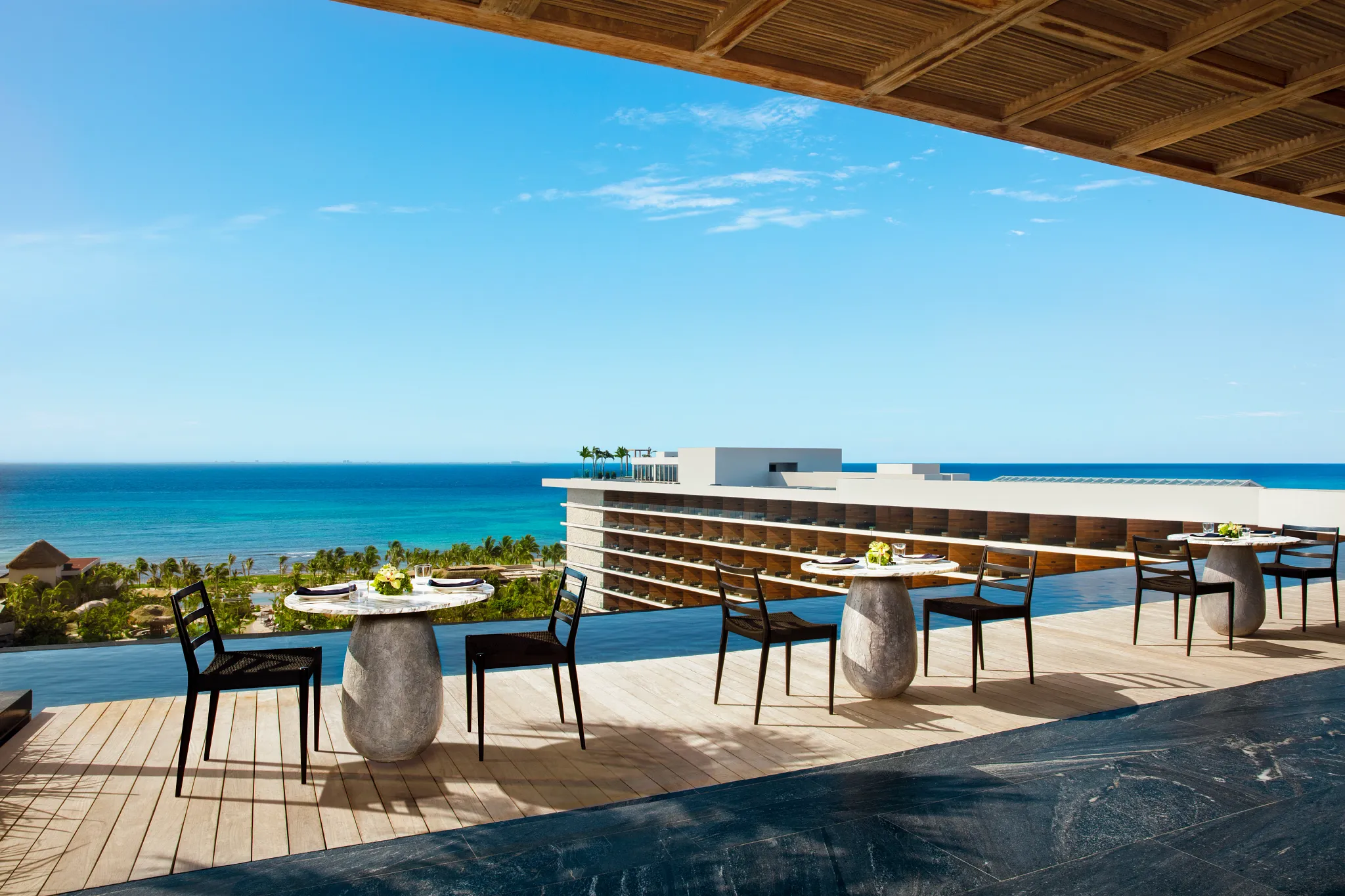 Observatory Preferred Rooftop at Impression Moxché by Secrets featuring infinity pool edge dining, panoramic ocean views, and elevated rooftop seating.